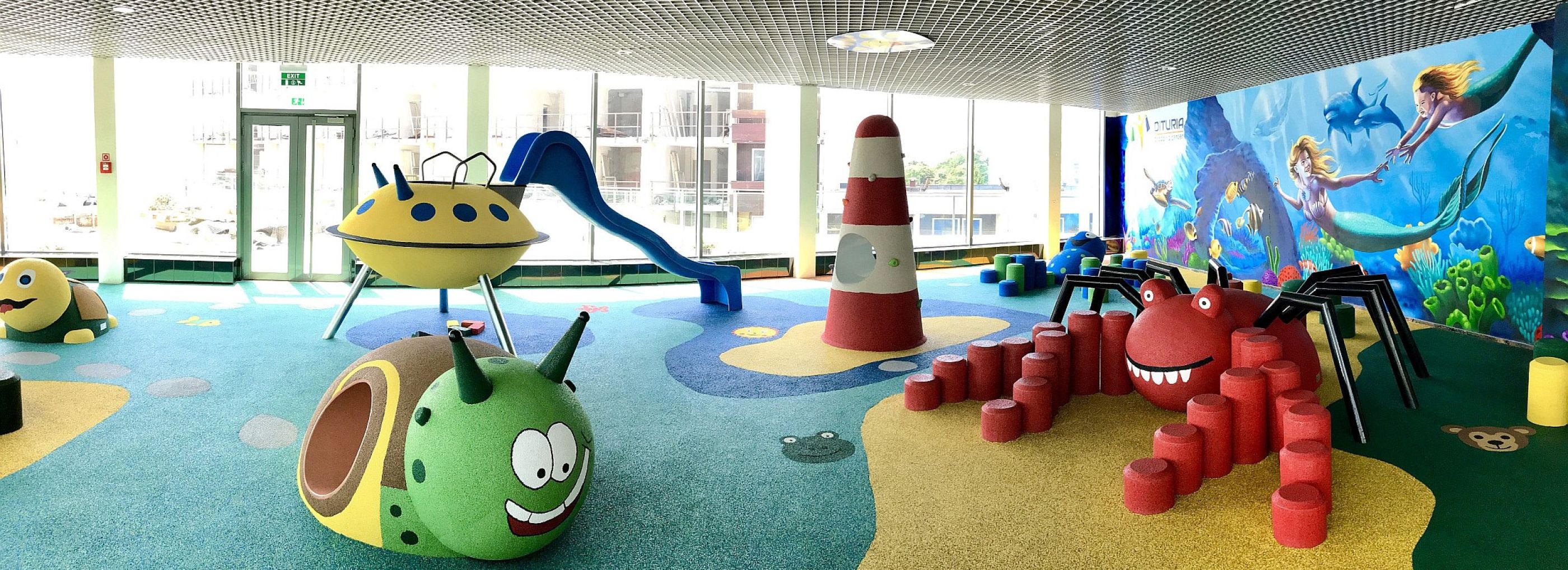 Beach theme indoor playground with a 3D spider and snail play animal.