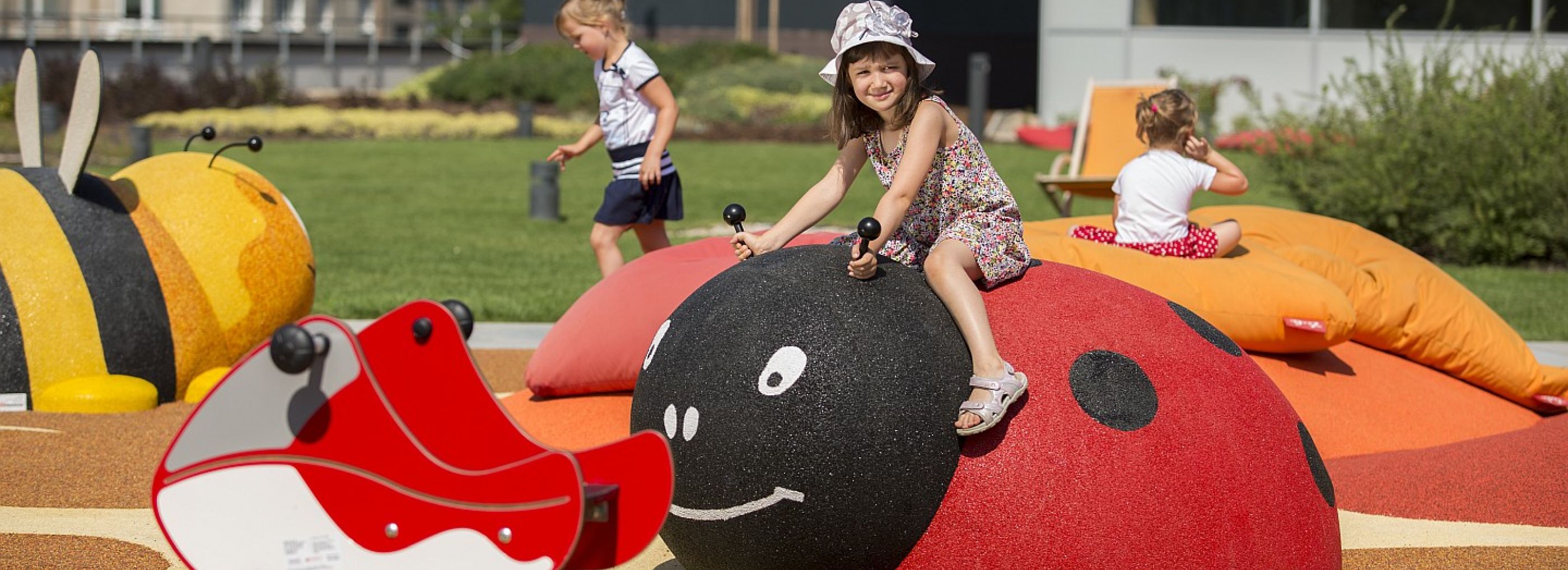 Young girl climbing on a 3D play animal shaped like a ladybird.